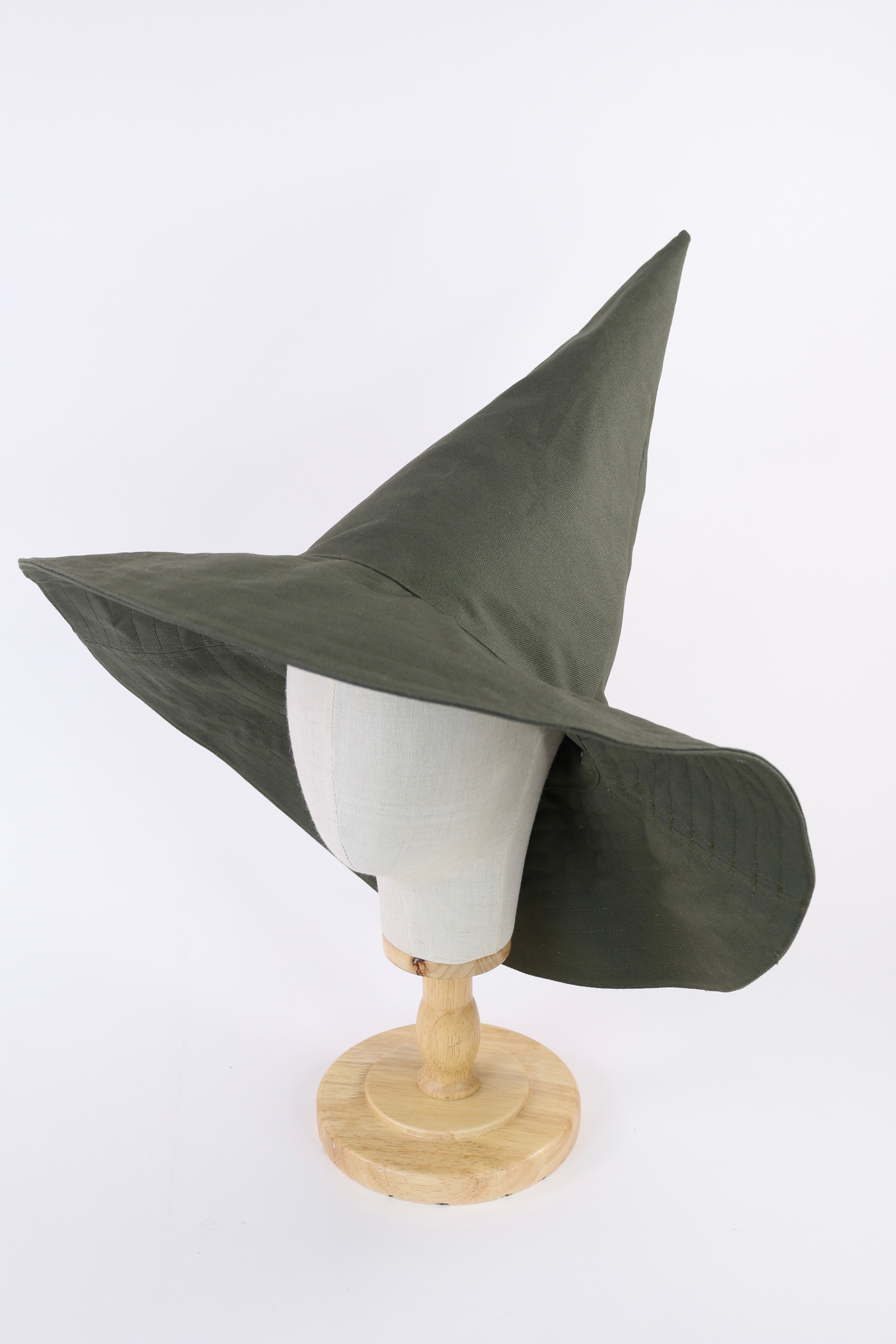 Green witch hat on a mannequin head against a white background