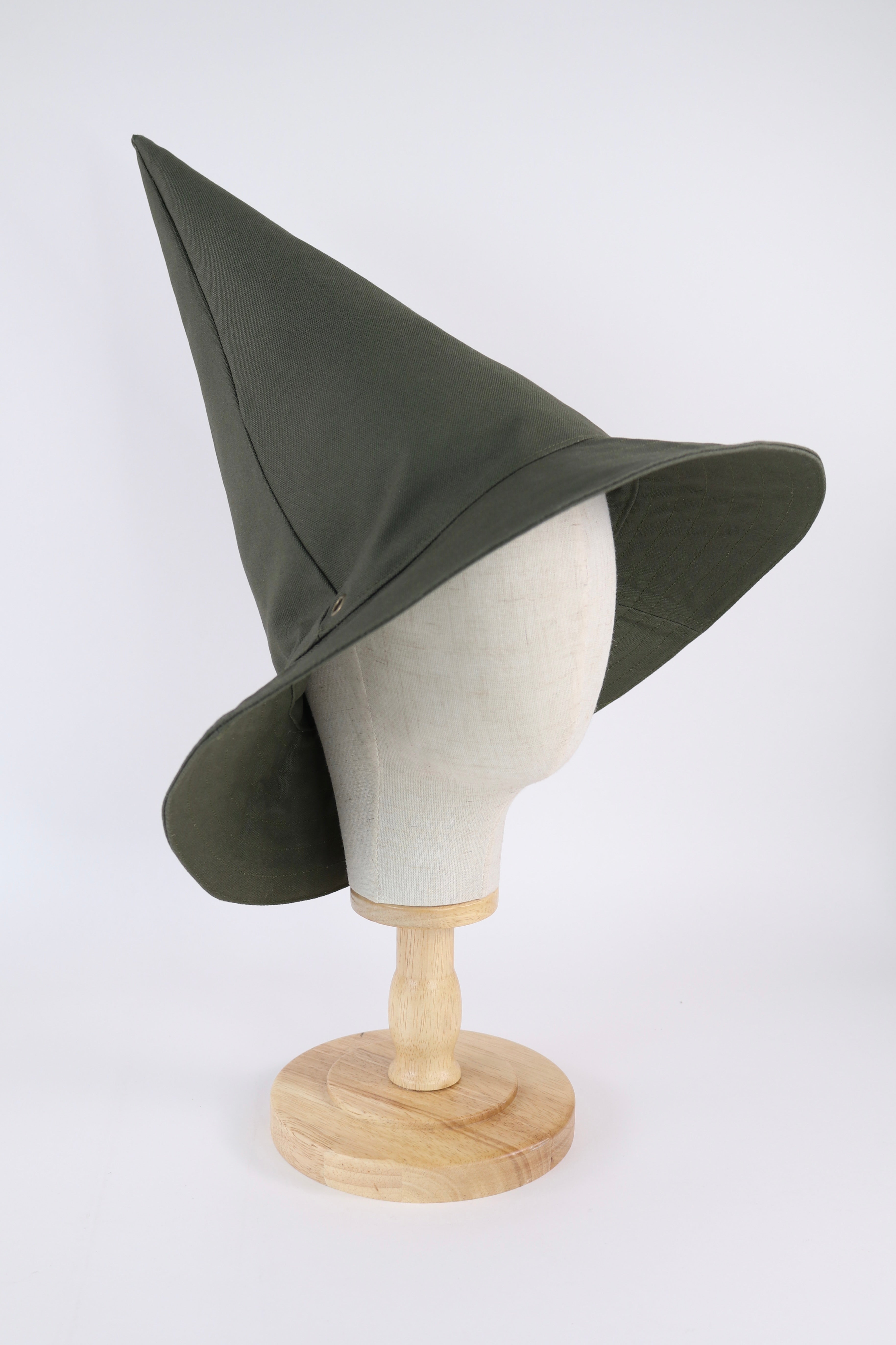 Green pointed hat on a mannequin head against a white background