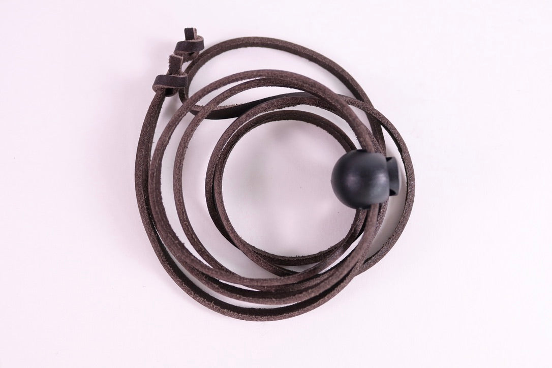Coiled brown leather strap on a white background