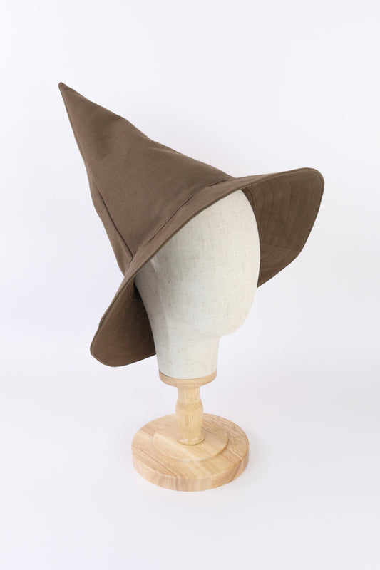 Brown witch hat on a mannequin head against a white background