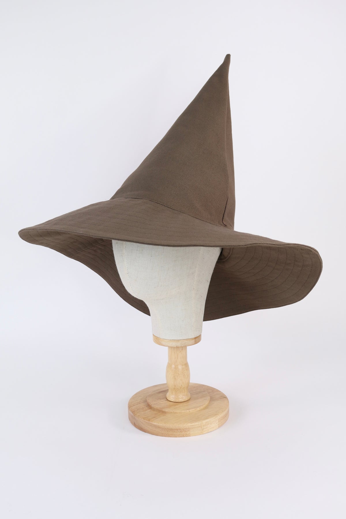 Brown pointed hat on a mannequin head against a white background