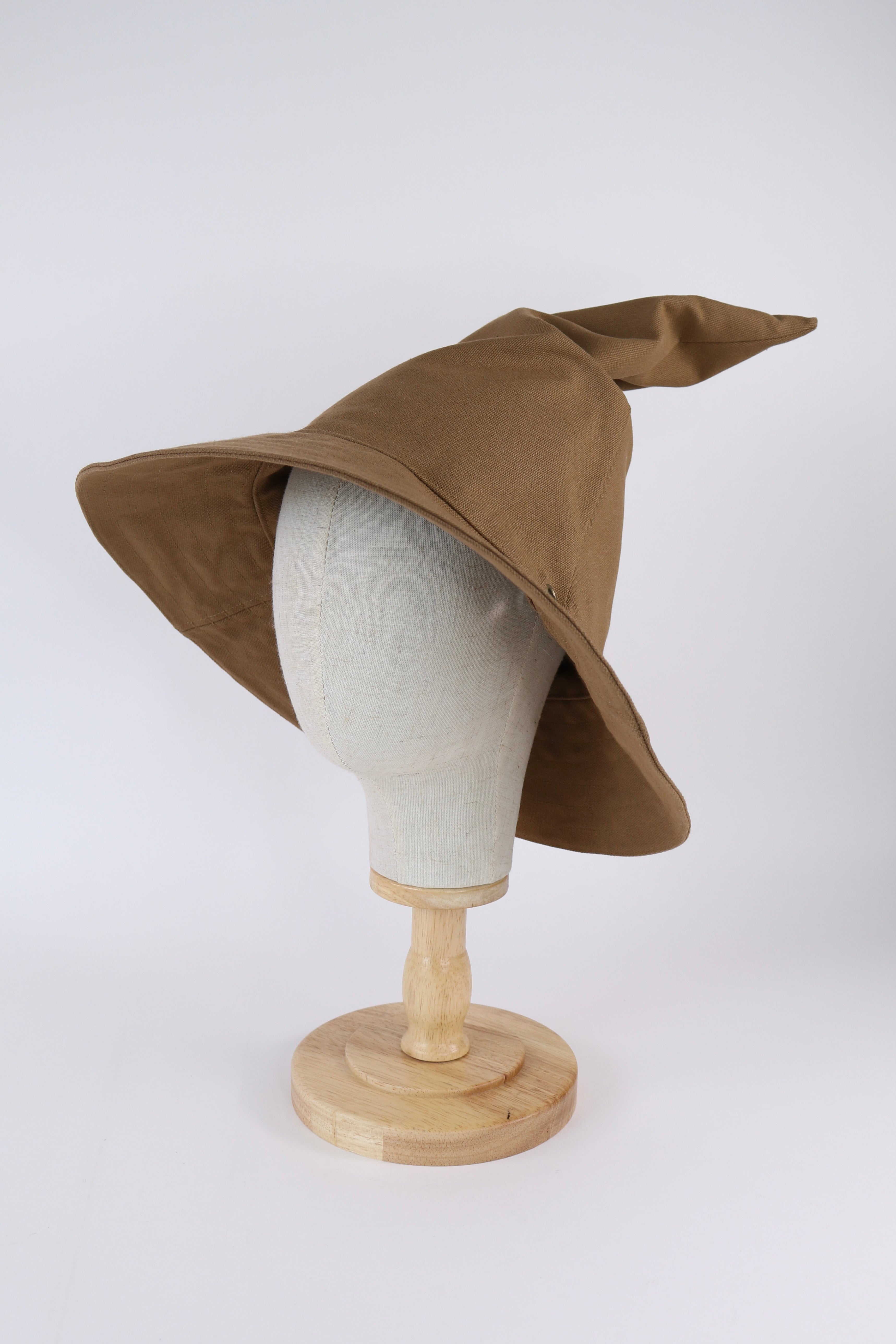 Brown witch hat on a mannequin head against a white background