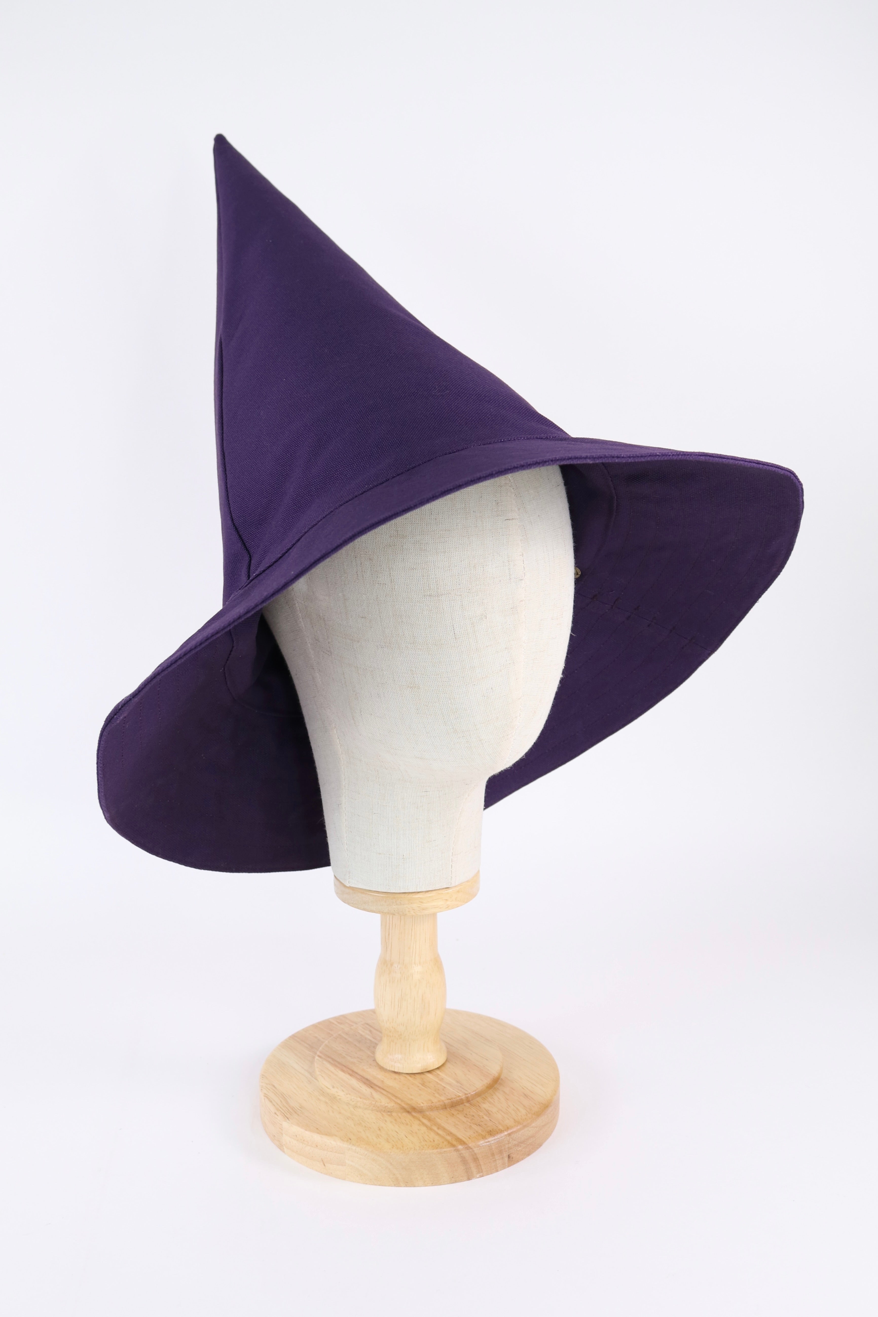 Purple witch hat on a mannequin head against a white background