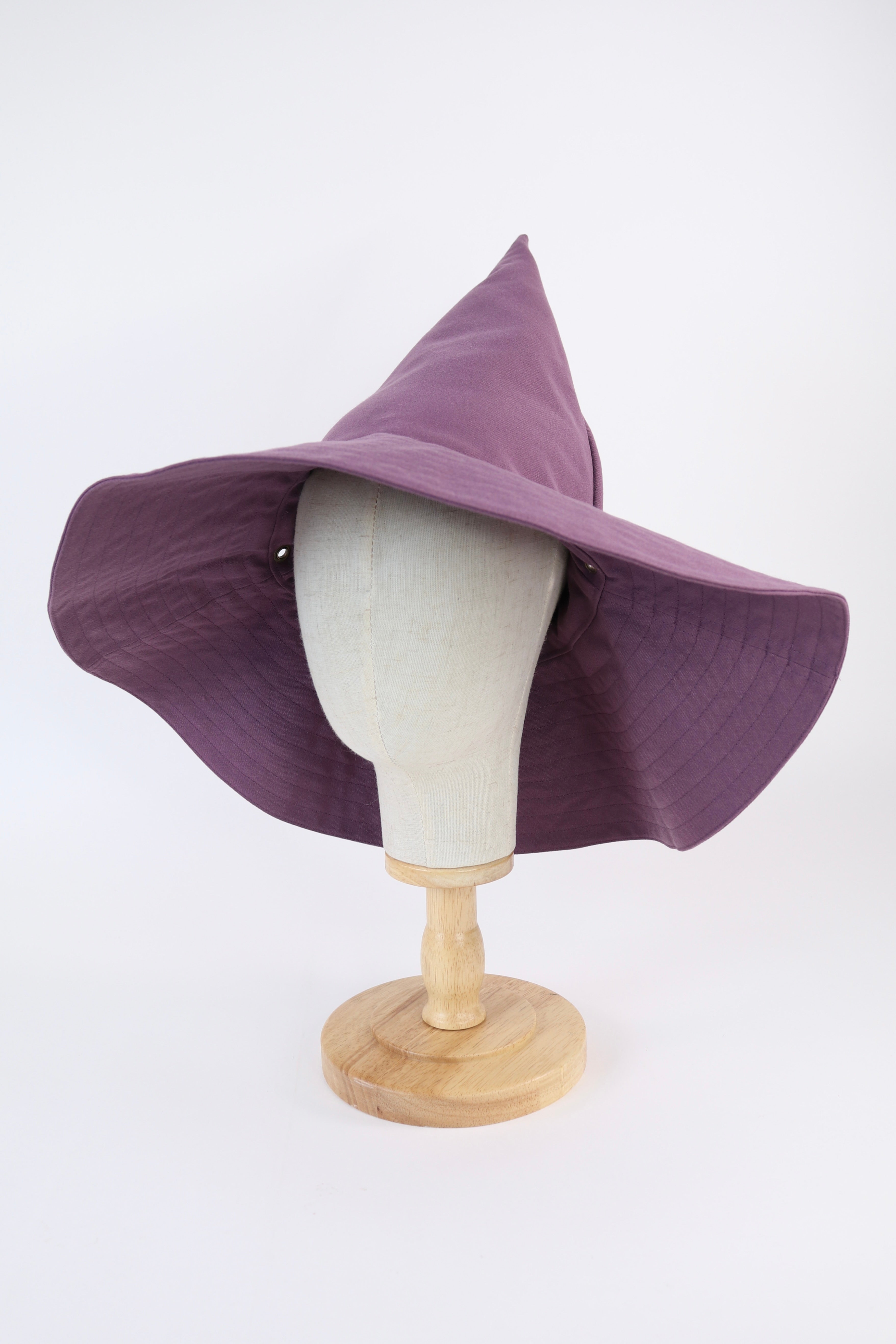 Purple witch hat on a mannequin head with a white background