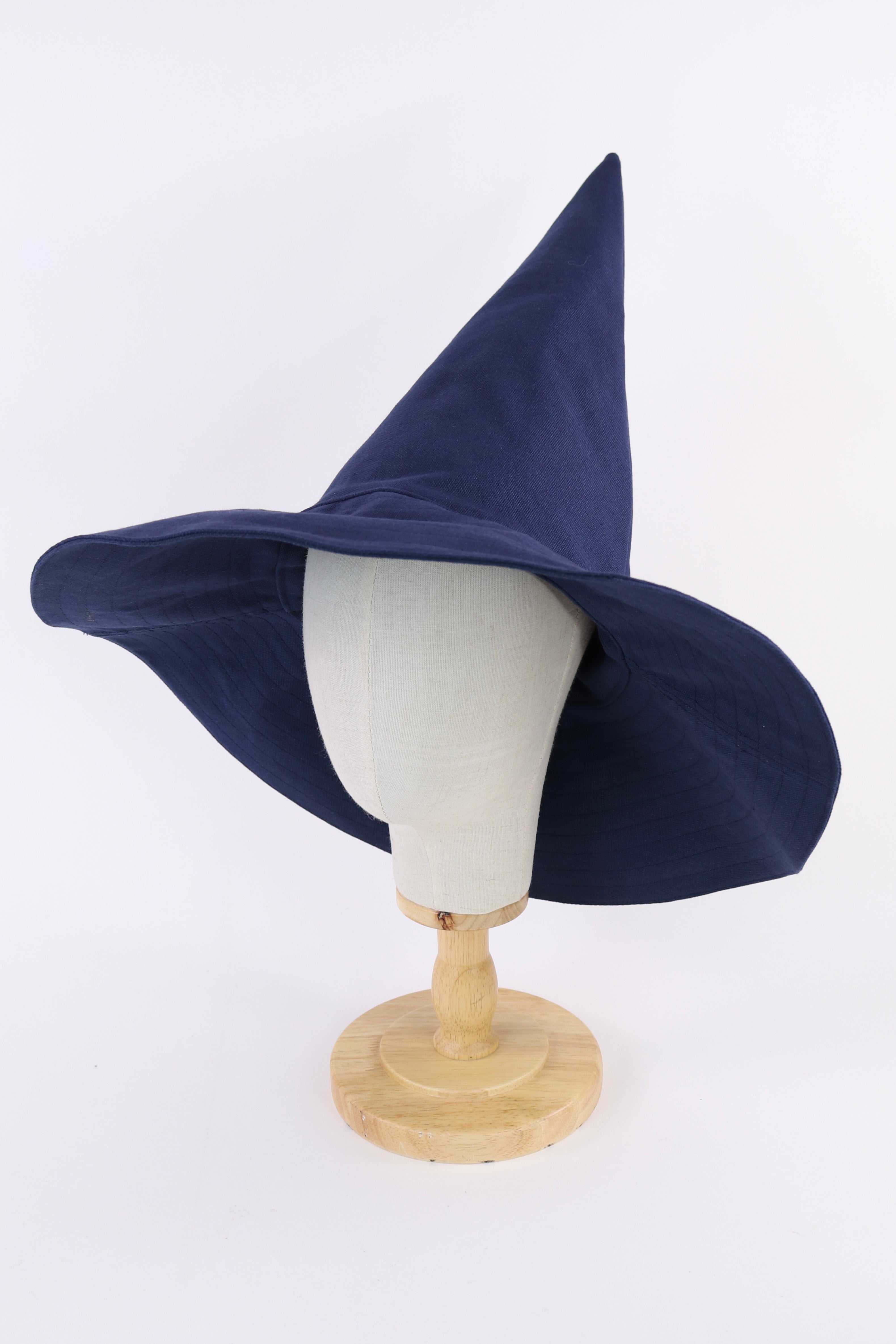 Navy blue witch hat on a mannequin head against a white background