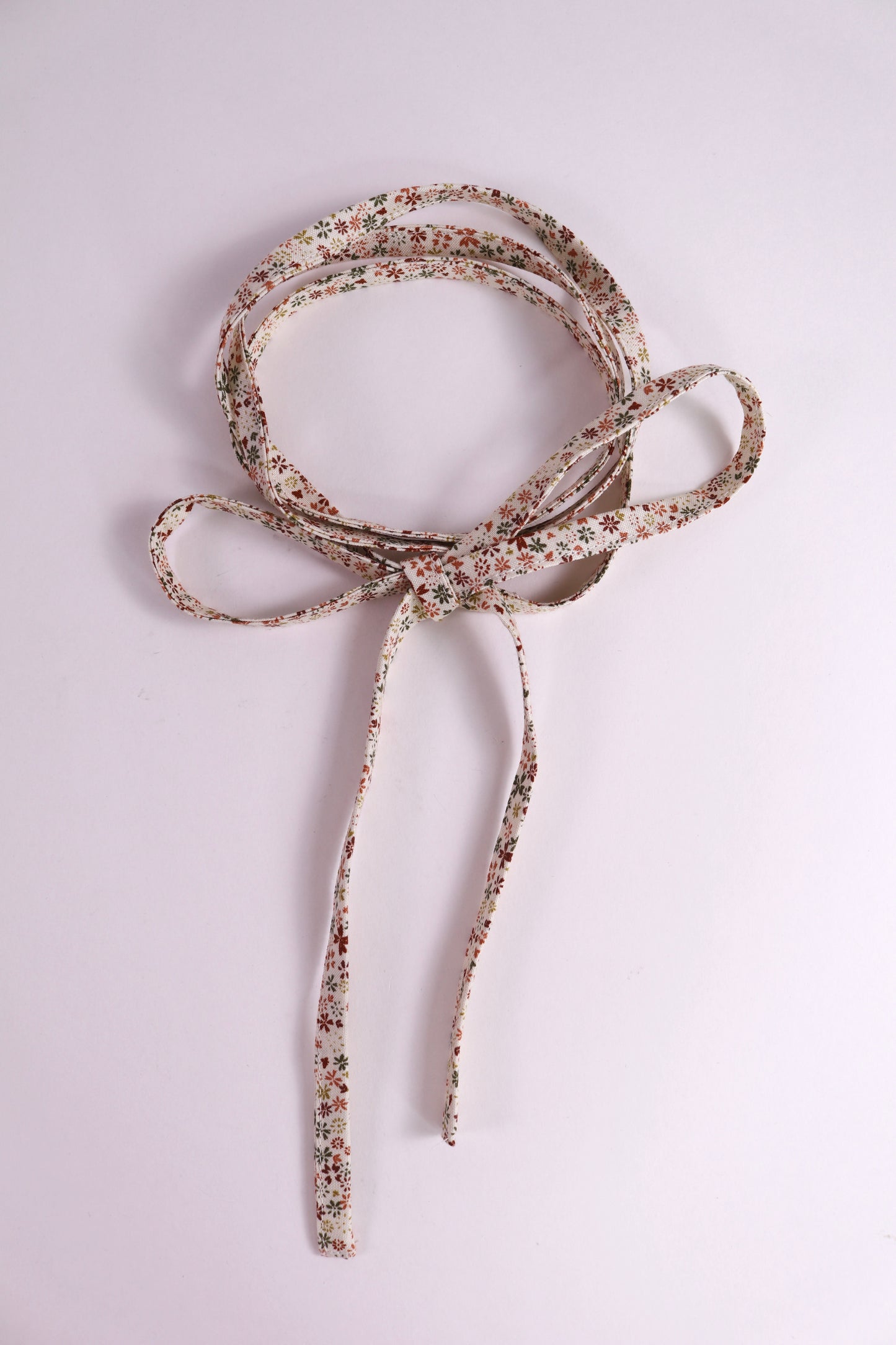 Decorative rusty toned cotton tie with a floral pattern
